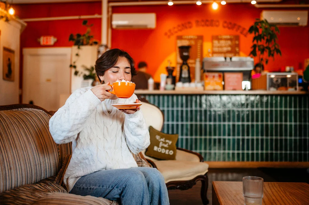 Person enjoying a vibrant coffee in a cozy café setting