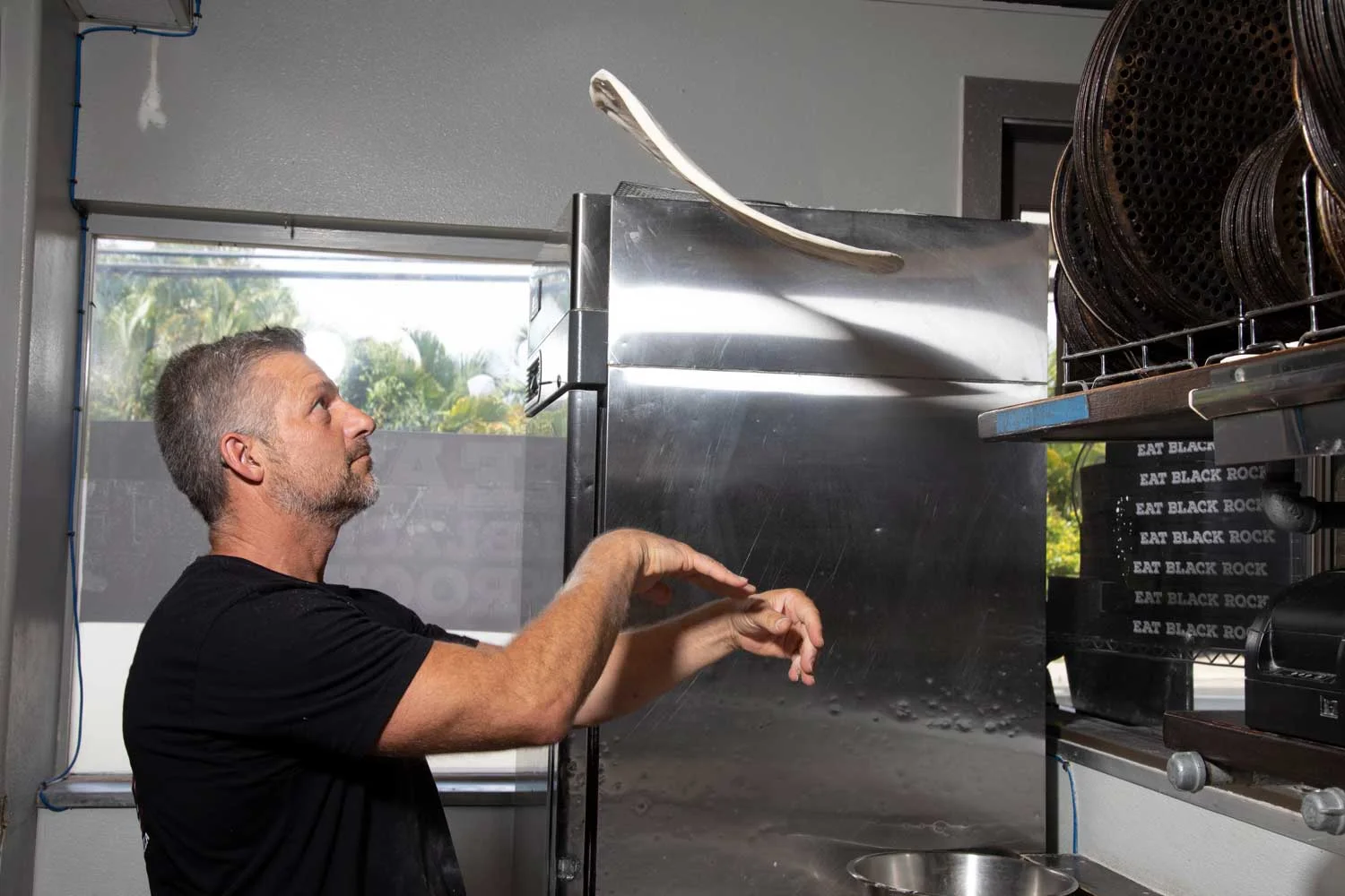 Chef tossing dough in a modern kitchen