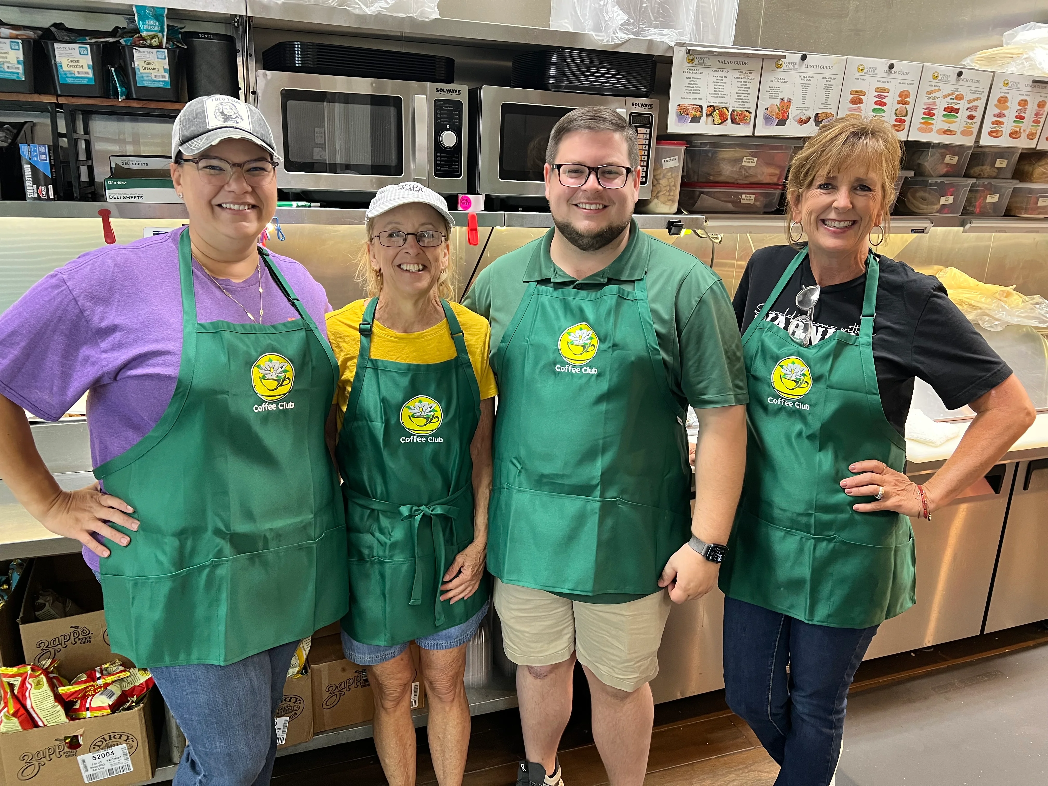 Team members in green aprons at Coffee Club restaurant kitchen