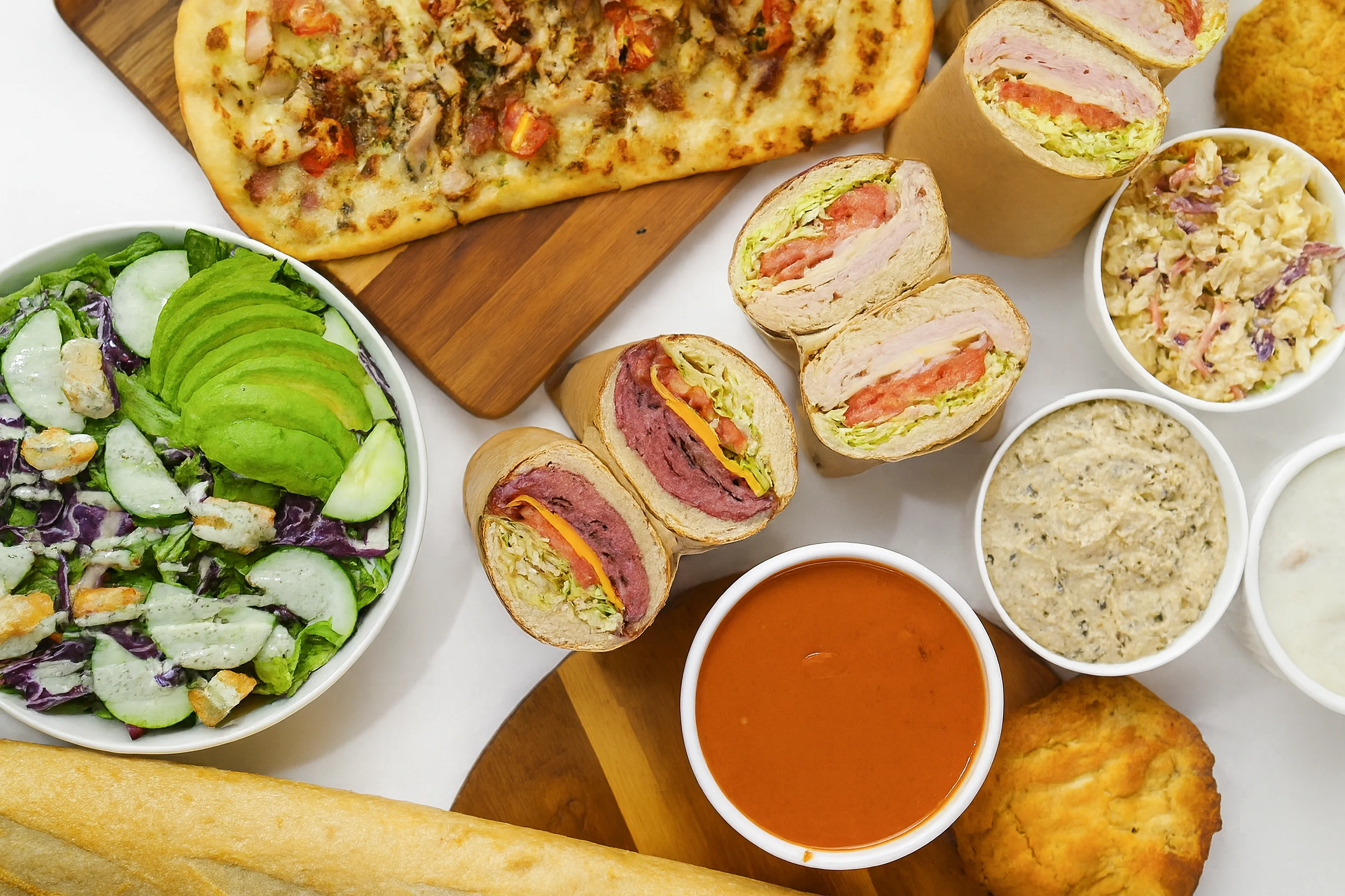 A sandwich filled with roast beef, Swiss cheese, and red onions, served in a toasted baguette with a side of dipping sauce.