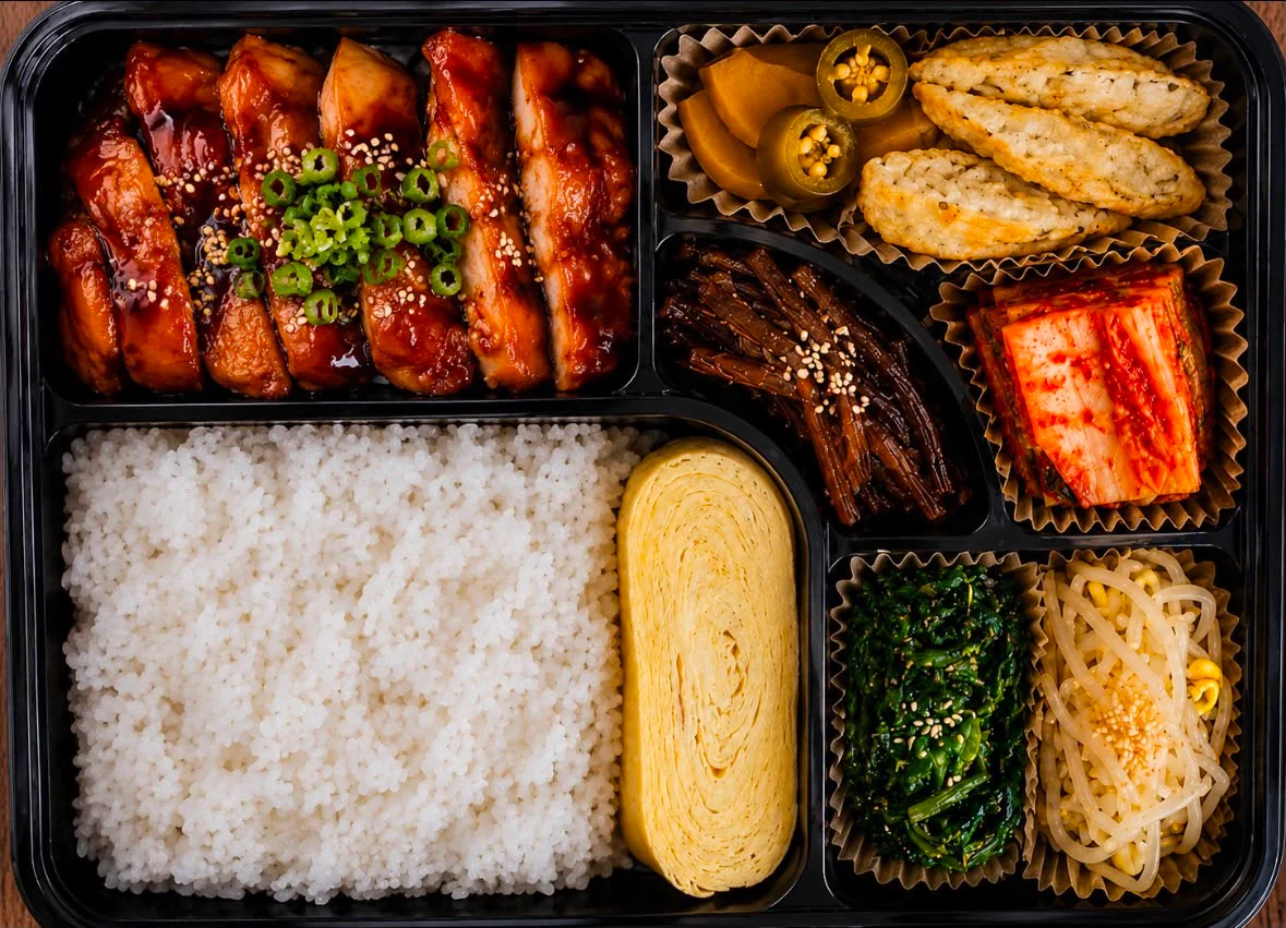 Korean bibimbap with assorted side dishes in a bento box