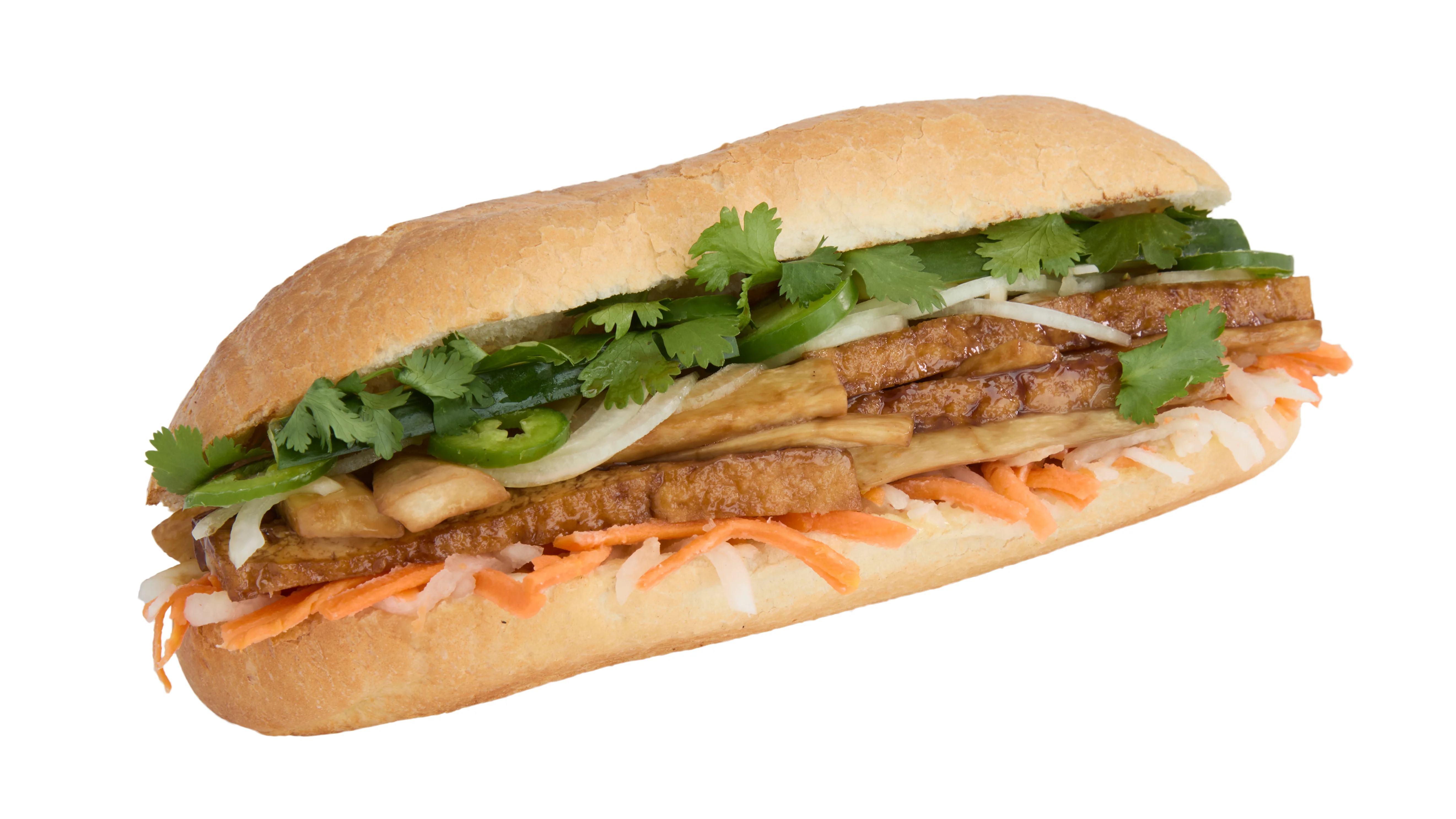 Vegan banh mi sandwich with fresh vegetables and herbs on a wooden table.