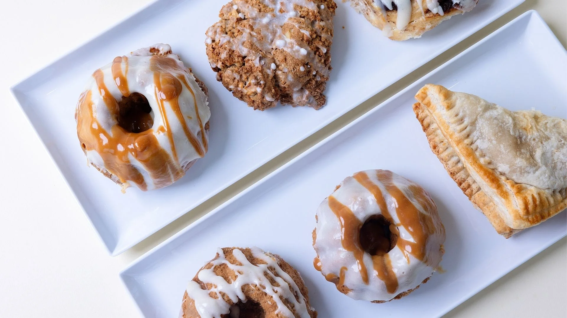 Assorted gourmet donuts and pastries on white plates