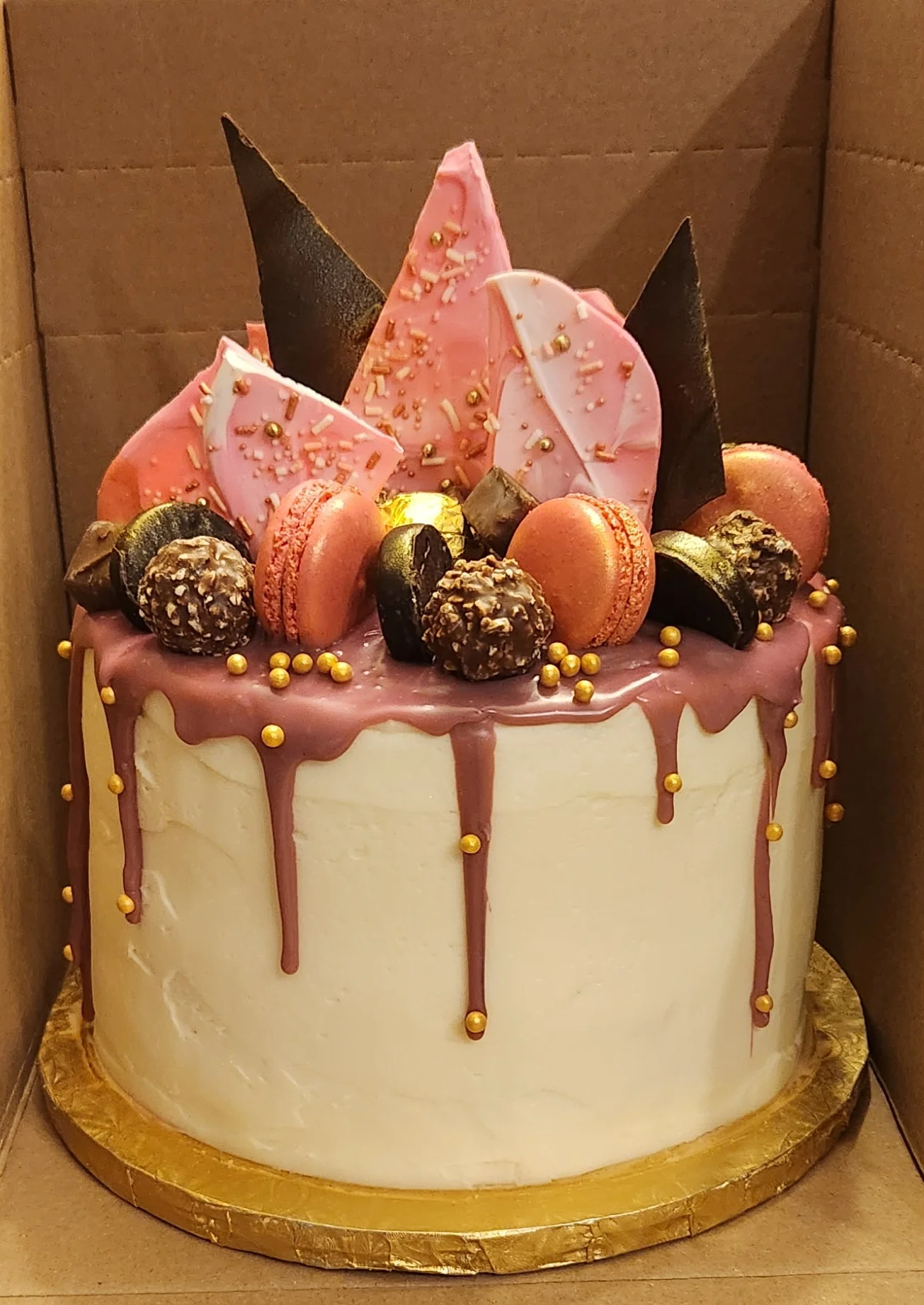 Elegant birthday cake with chocolate and macarons