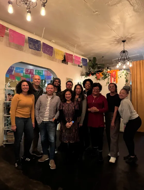 Group of people posing together in a vibrant restaurant setting.