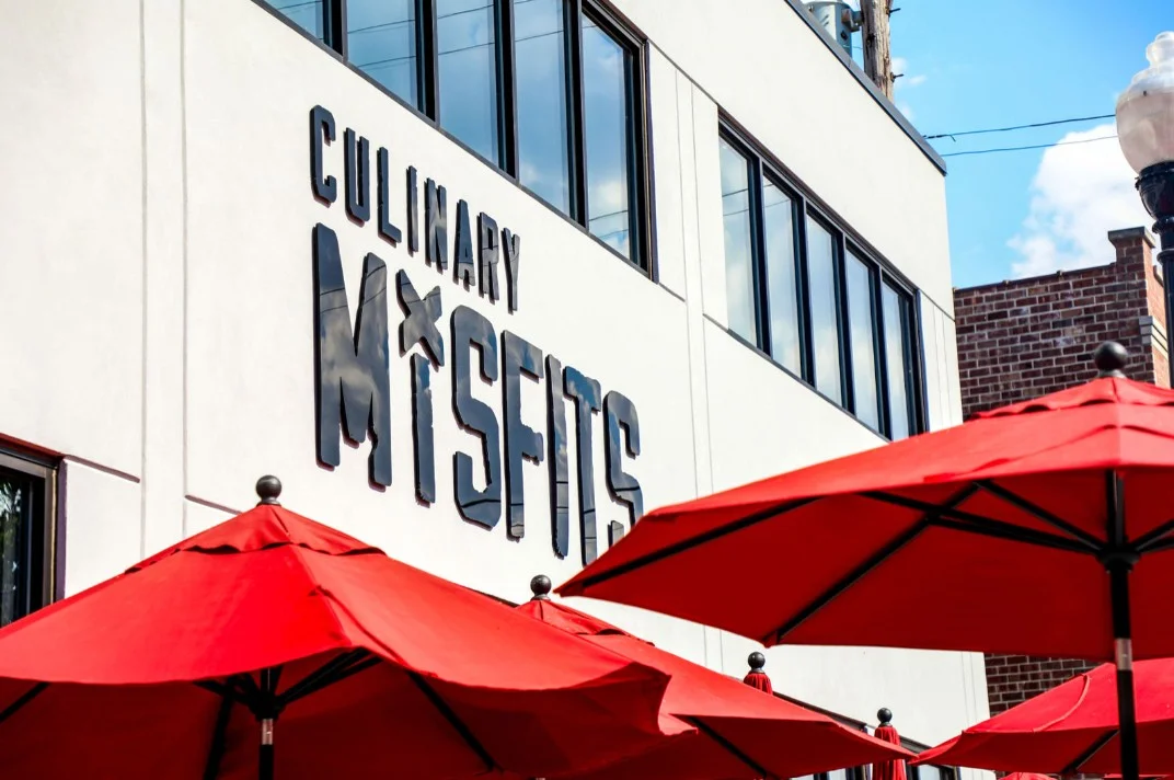 Exterior view of a modern restaurant with outdoor seating and vibrant decor.