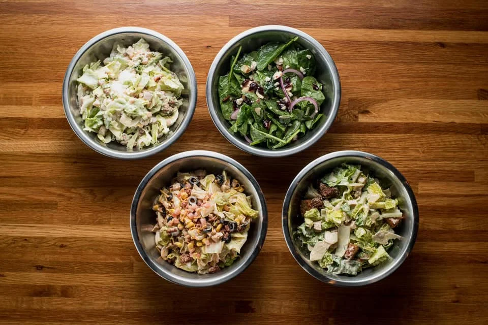Assorted fresh salads in metal bowls