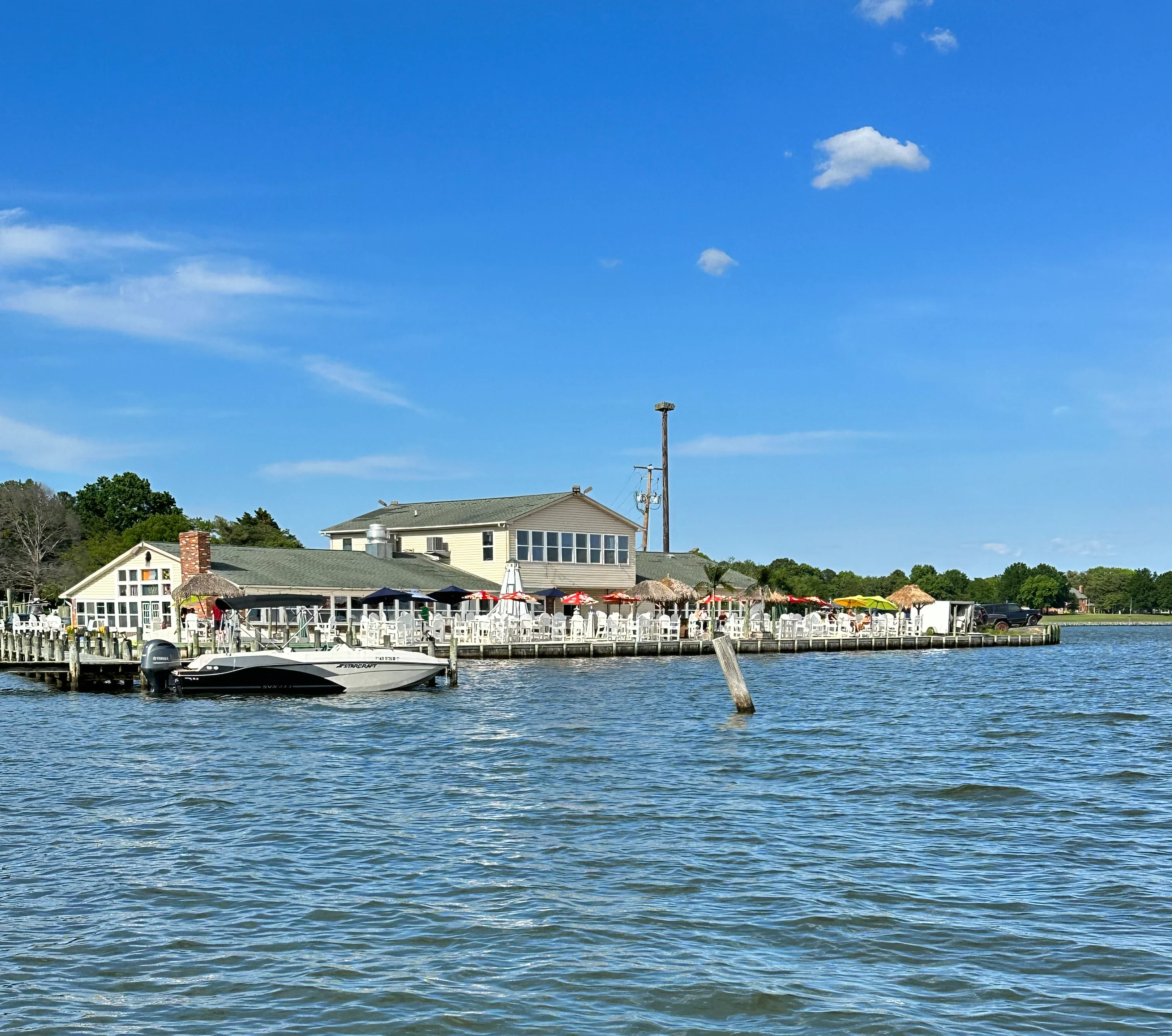 Waterfront restaurant with outdoor seating and a boat dock.