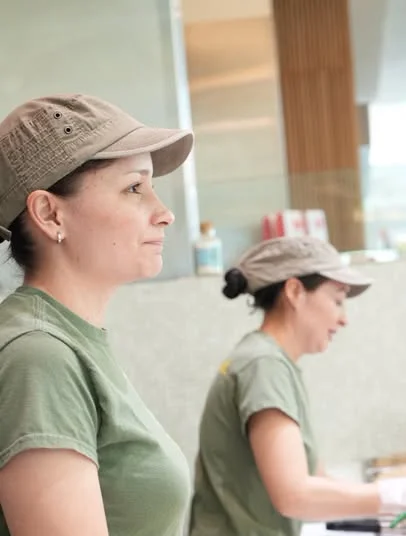 Two restaurant staff preparing food behind a counter