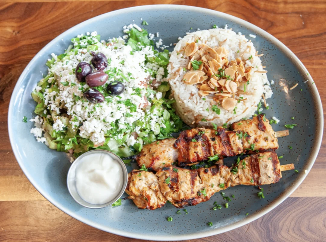 Two marinated grilled chicken skewers served with your choice of sides at Sufrat.