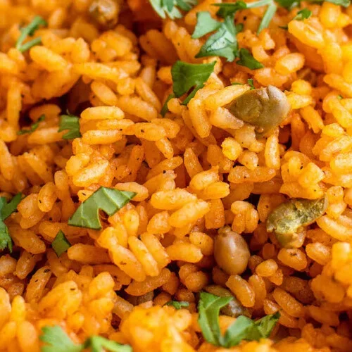 Nigerian jollof rice garnished with fresh herbs