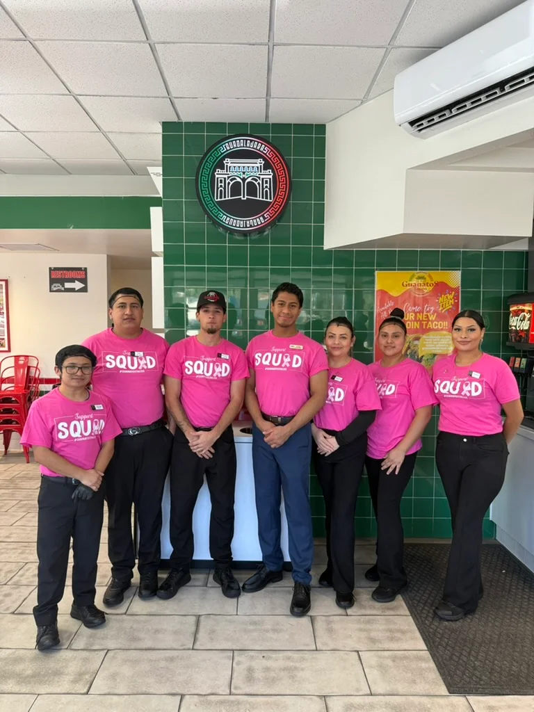 Restaurant staff posing together in vibrant uniforms