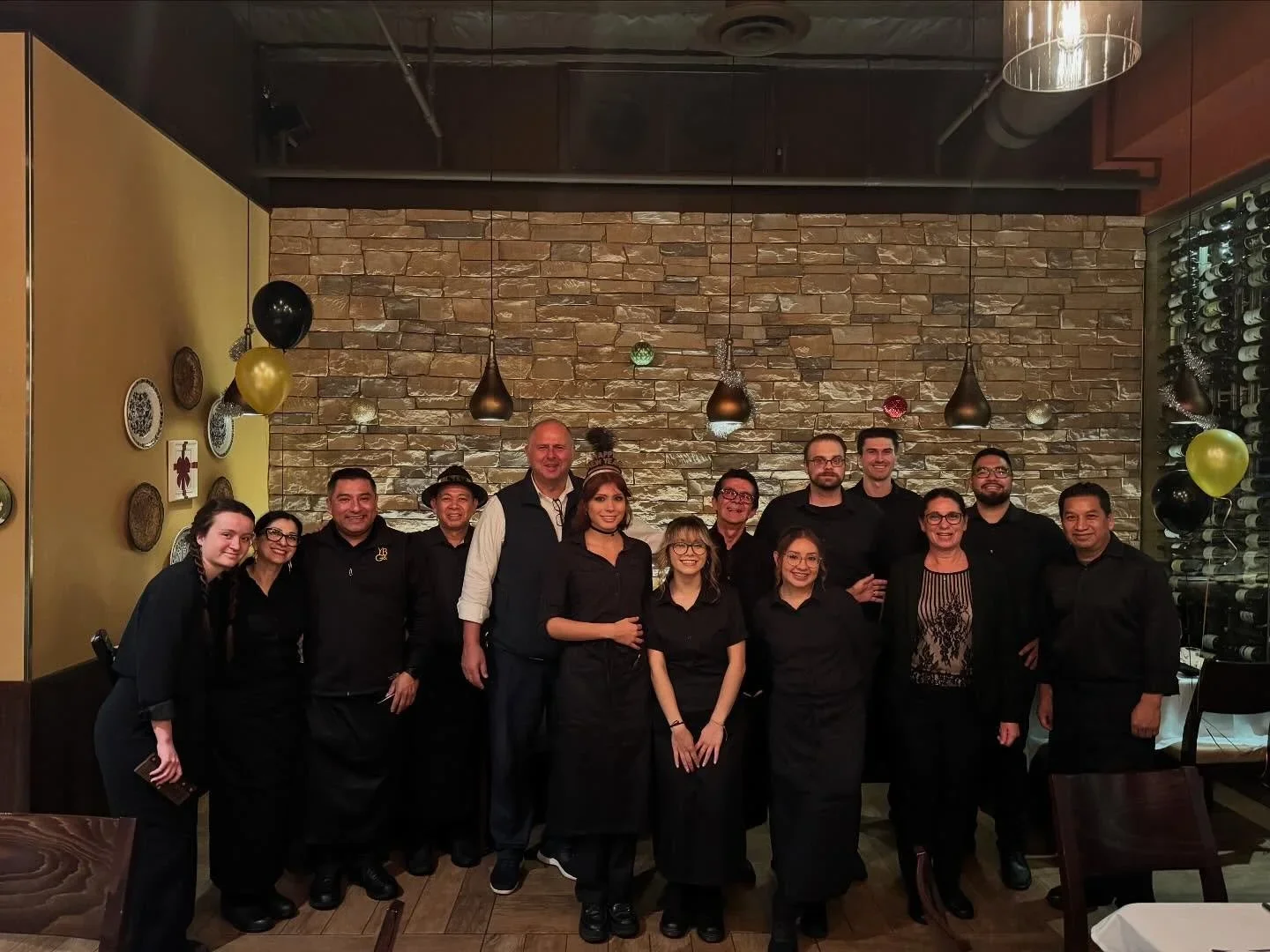Restaurant staff posing together in a cozy dining area