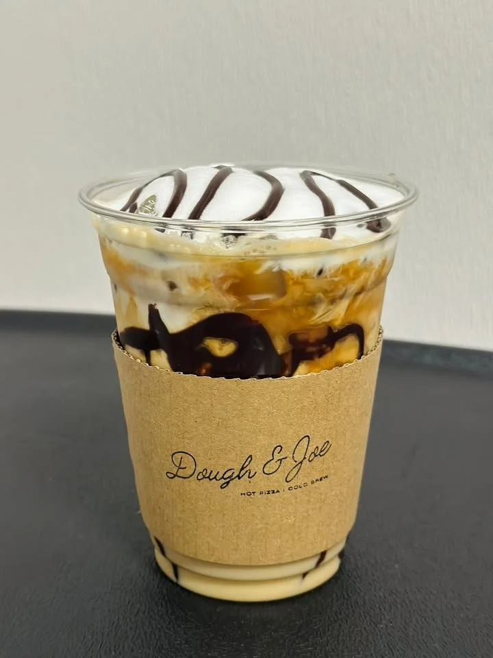Iced caramel macchiato in a clear cup with whipped cream