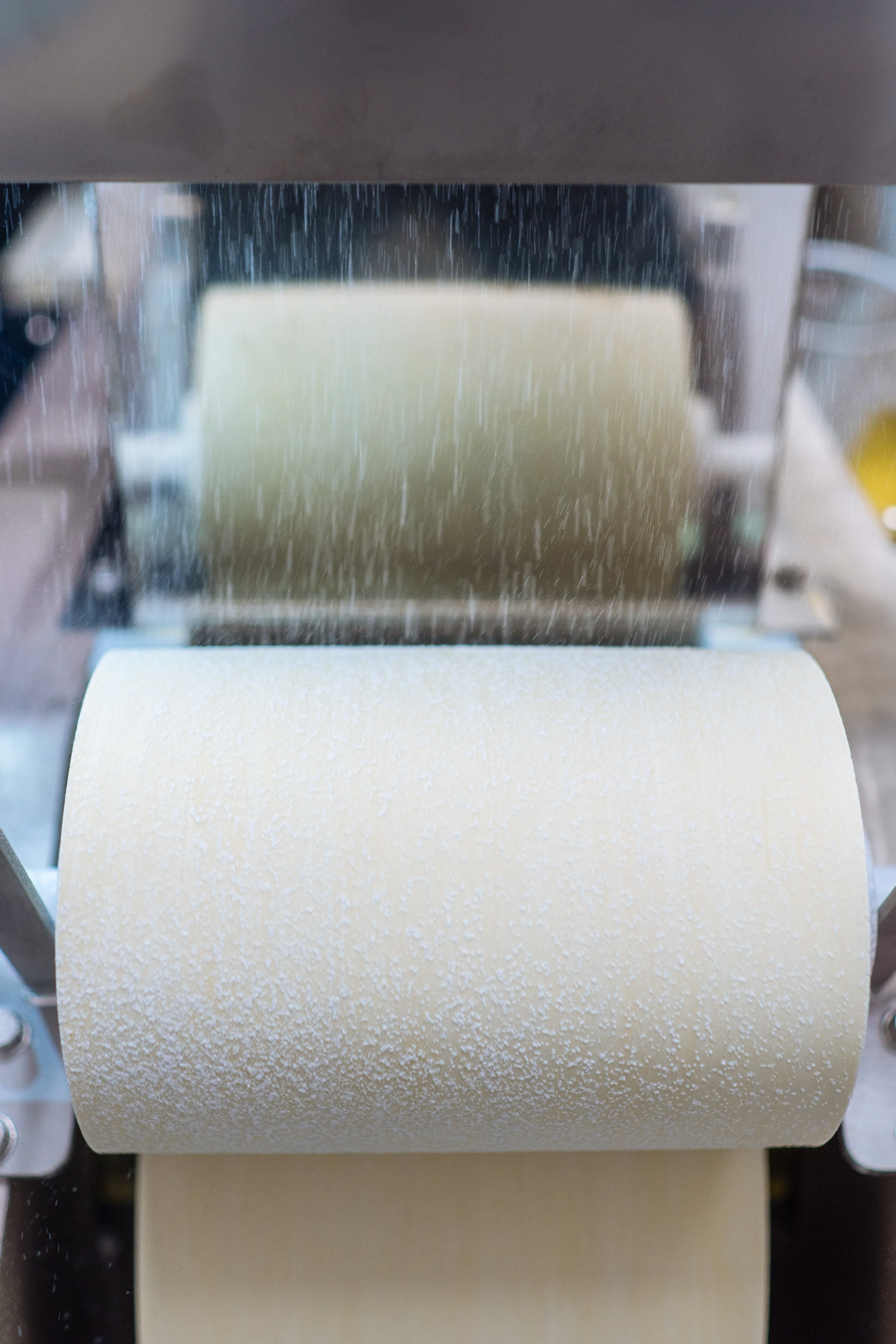 Pasta machine rolling fresh dough for Italian pasta