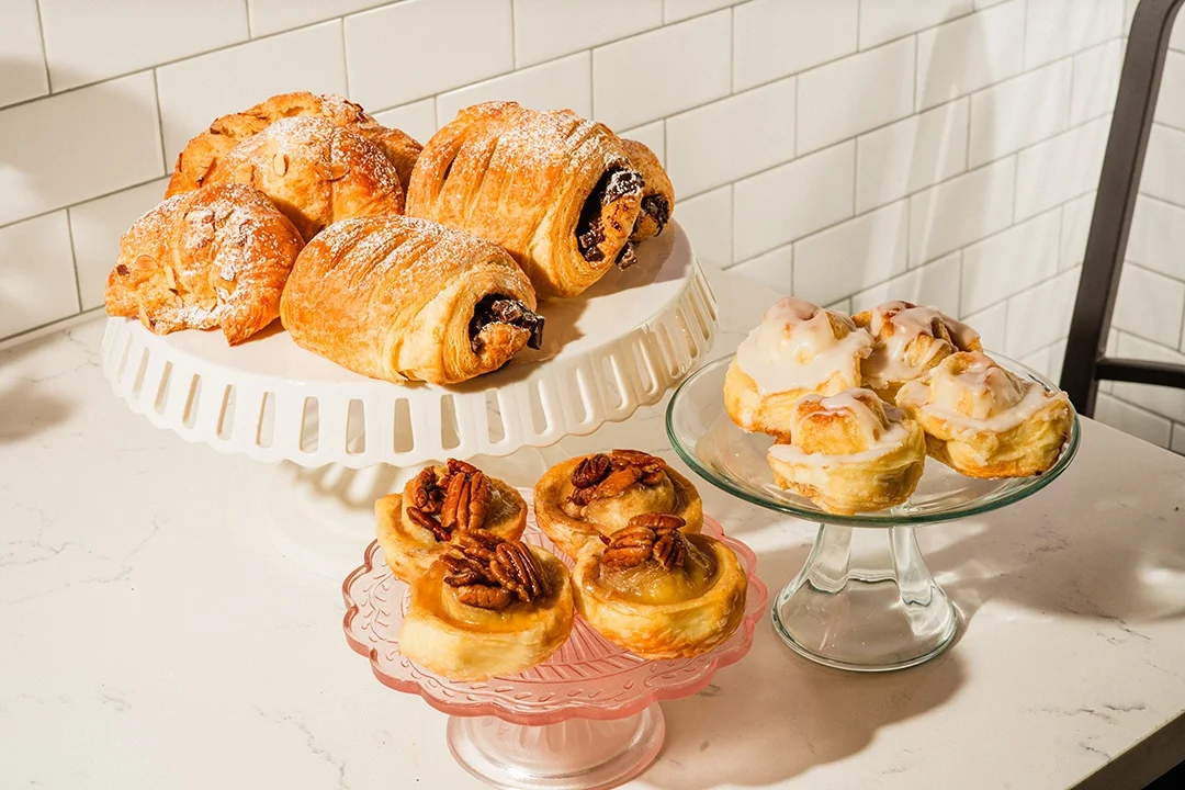 Assorted pastries including croissants and sticky buns on display
