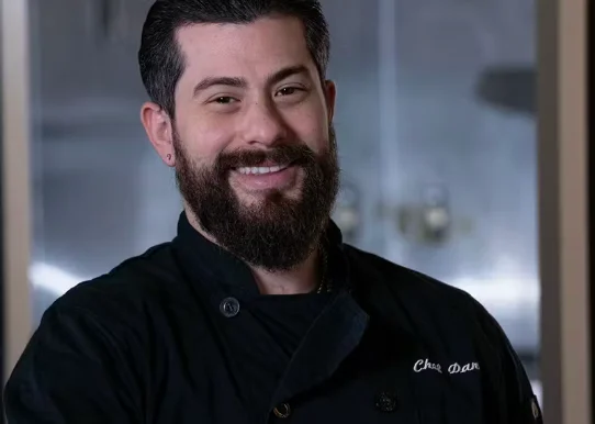 Chef smiling in a professional kitchen setting