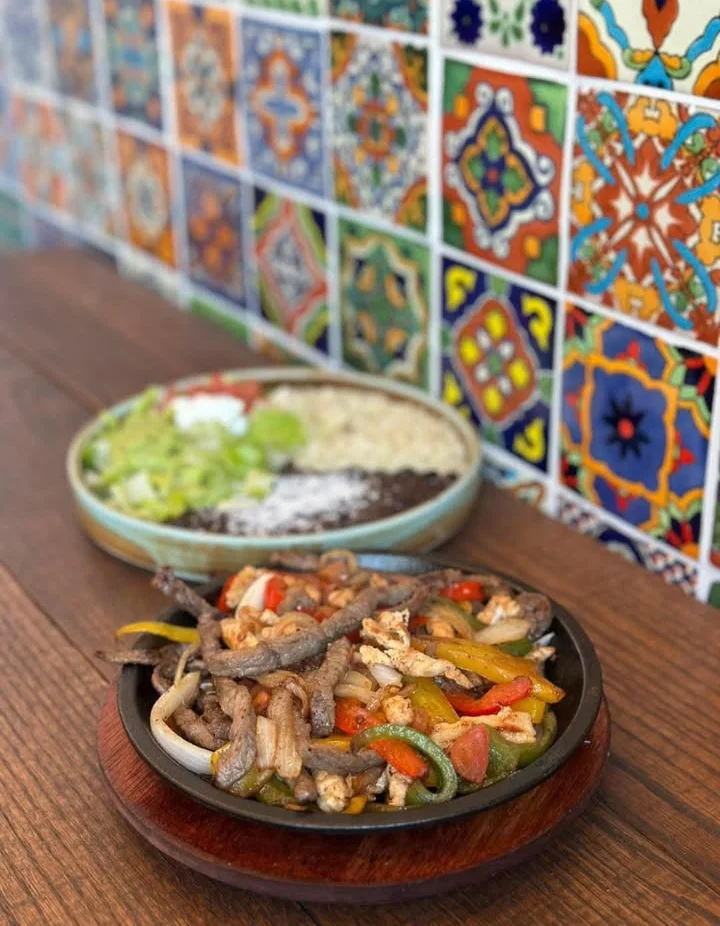 Sizzling fajitas served with rice and beans