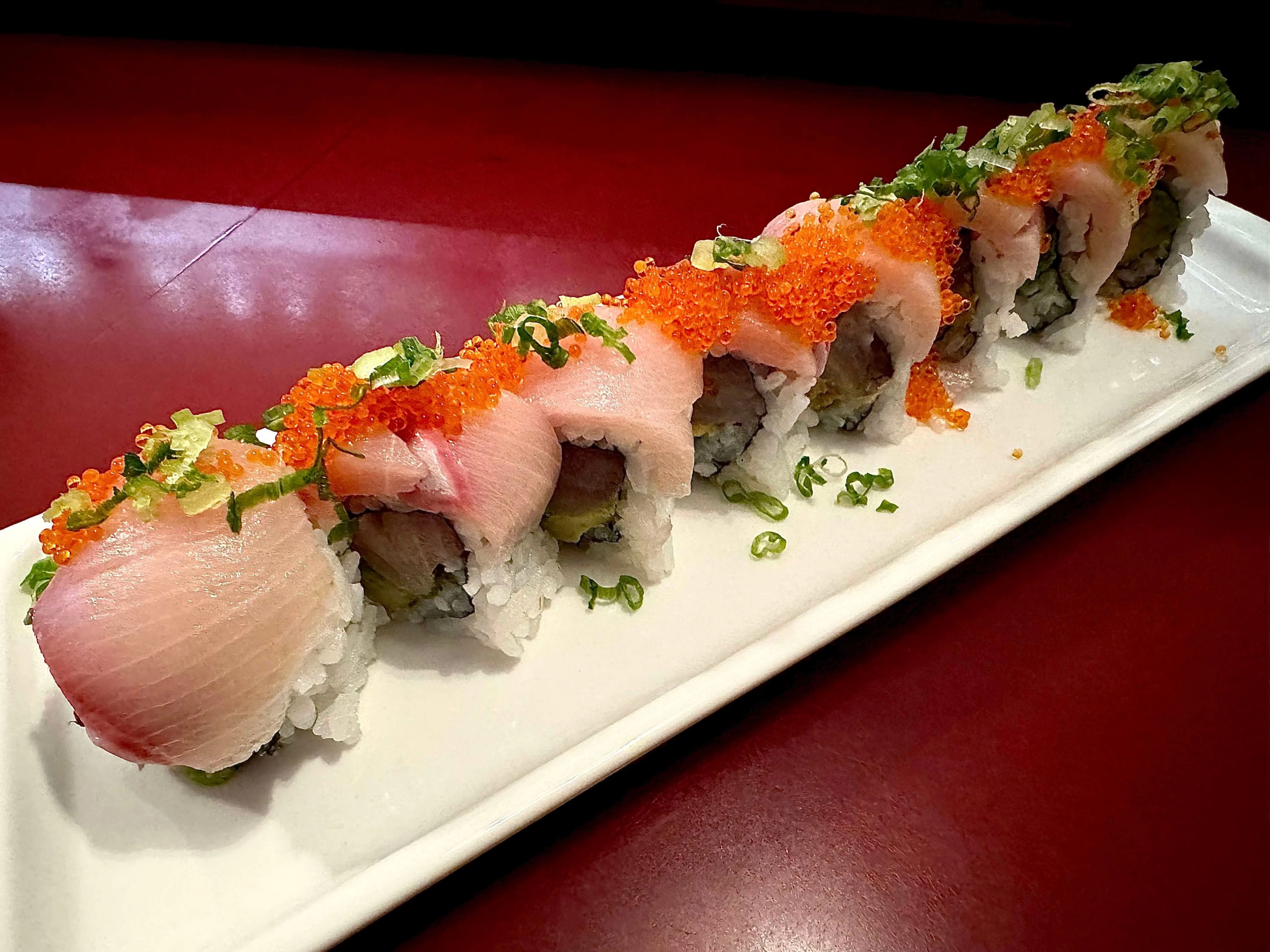 Japanese sushi roll topped with fresh fish and roe