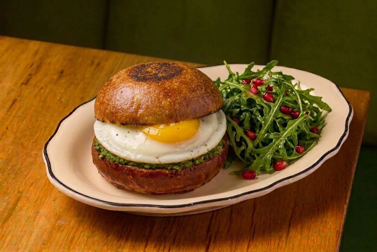 Brunch sandwich with fried egg and arugula salad