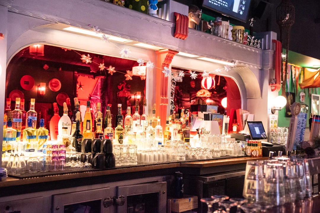 Vibrant bar counter with colorful liquor bottles and festive decor