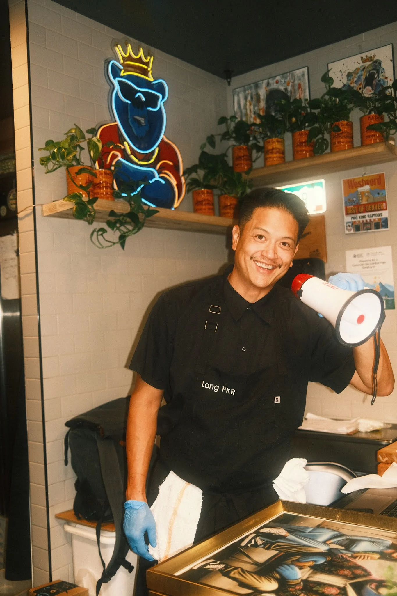 Chef smiling in a vibrant restaurant with neon decor