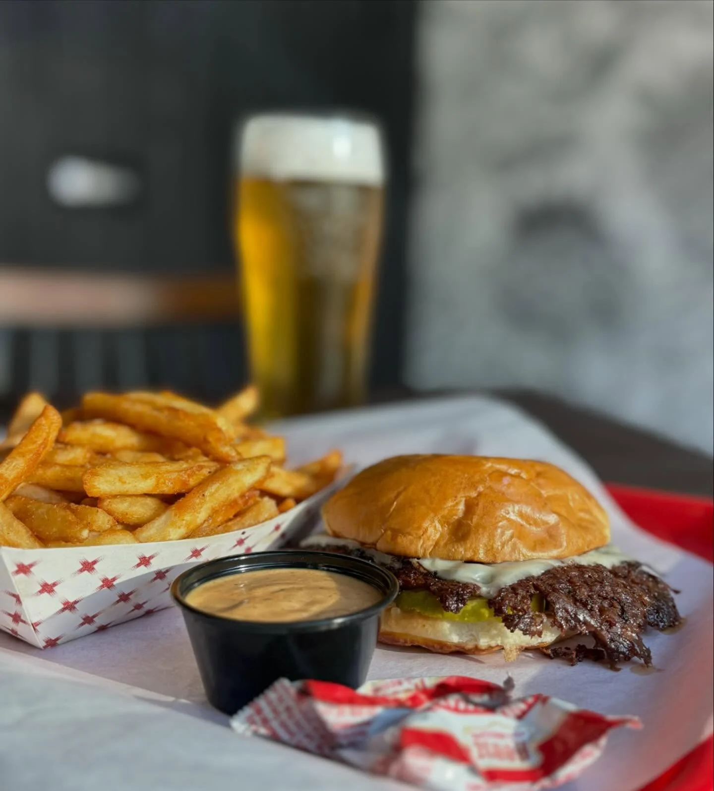 Juicy cheeseburger with fries and dipping sauce