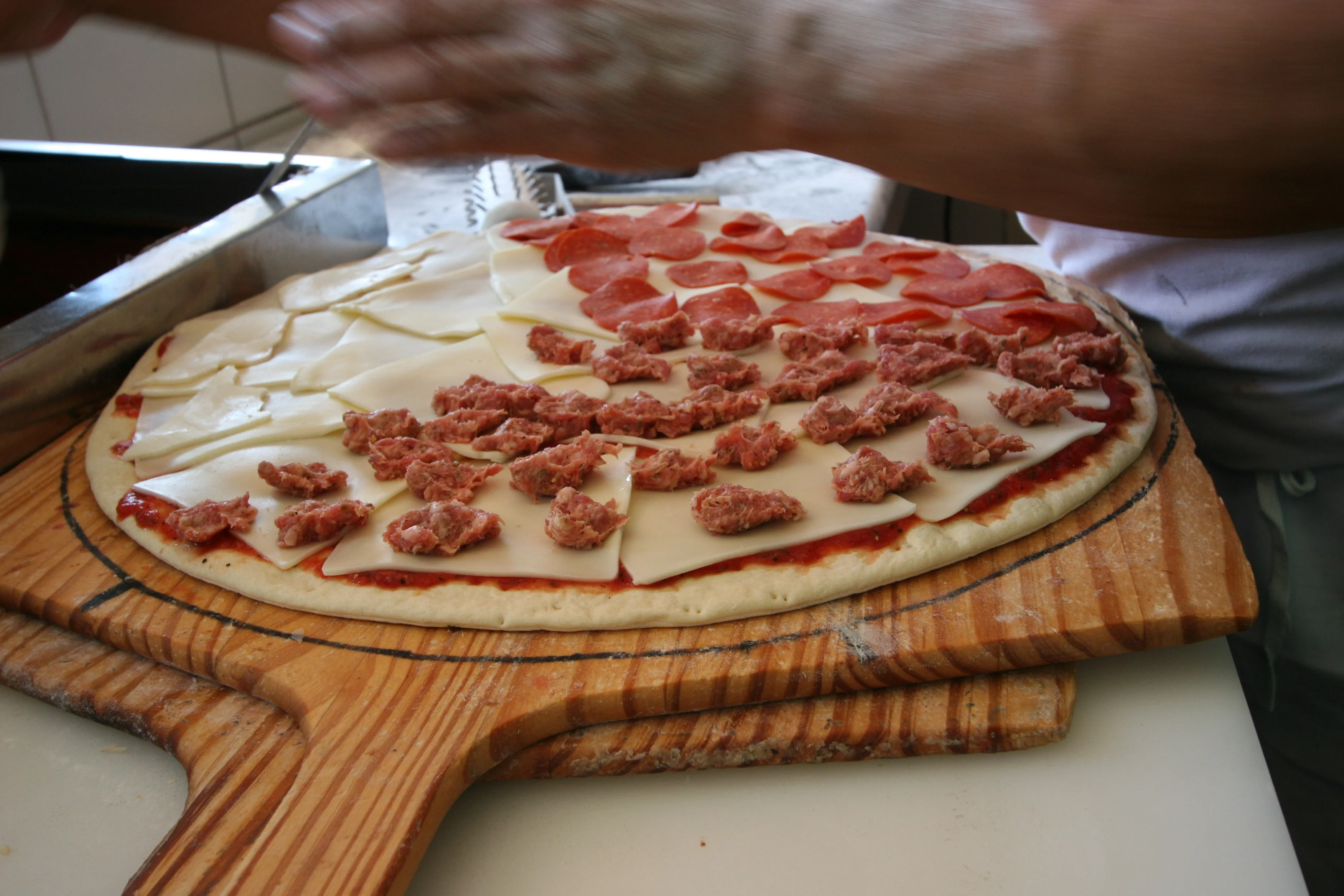 Preparing a classic Italian pizza with assorted toppings