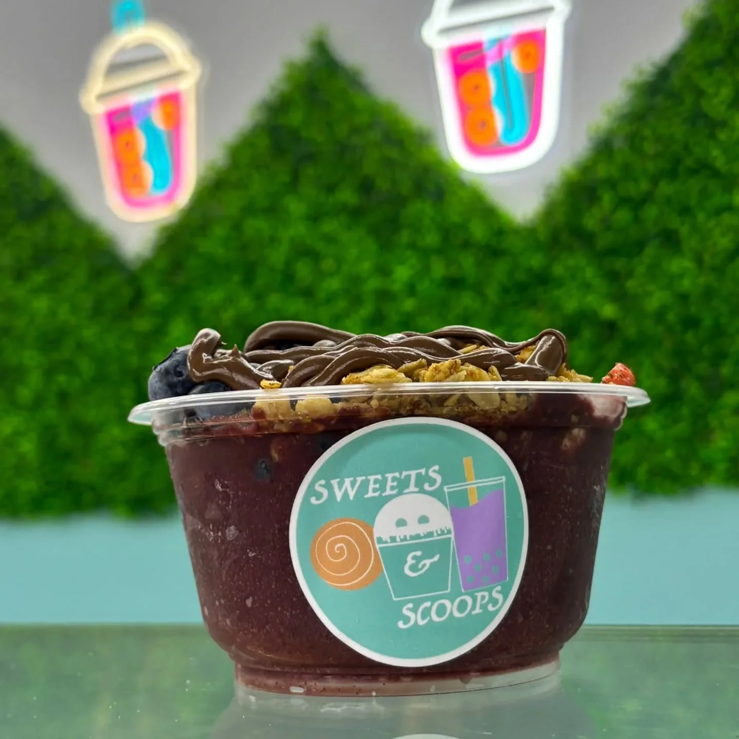 Acai bowl topped with granola and fresh berries in a vibrant café setting