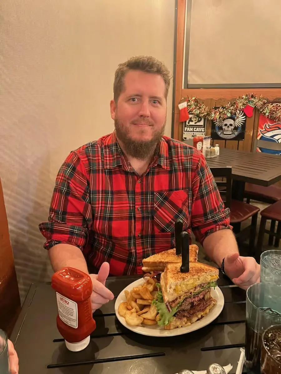 Giant club sandwich with fries in a casual dining setting