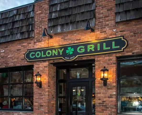 Exterior view of Colony Grill restaurant with warm lighting