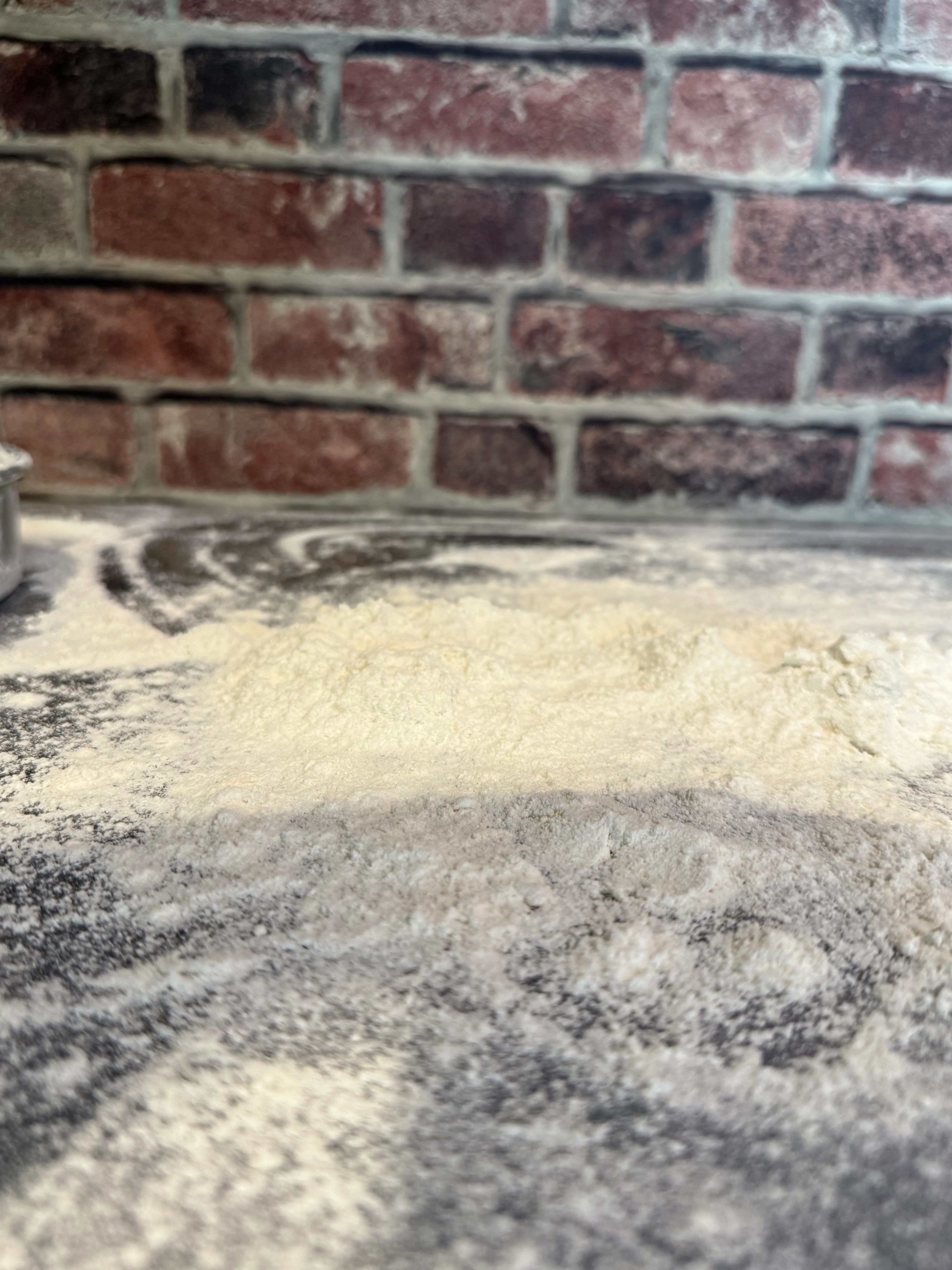 Flour spread on a rustic kitchen countertop