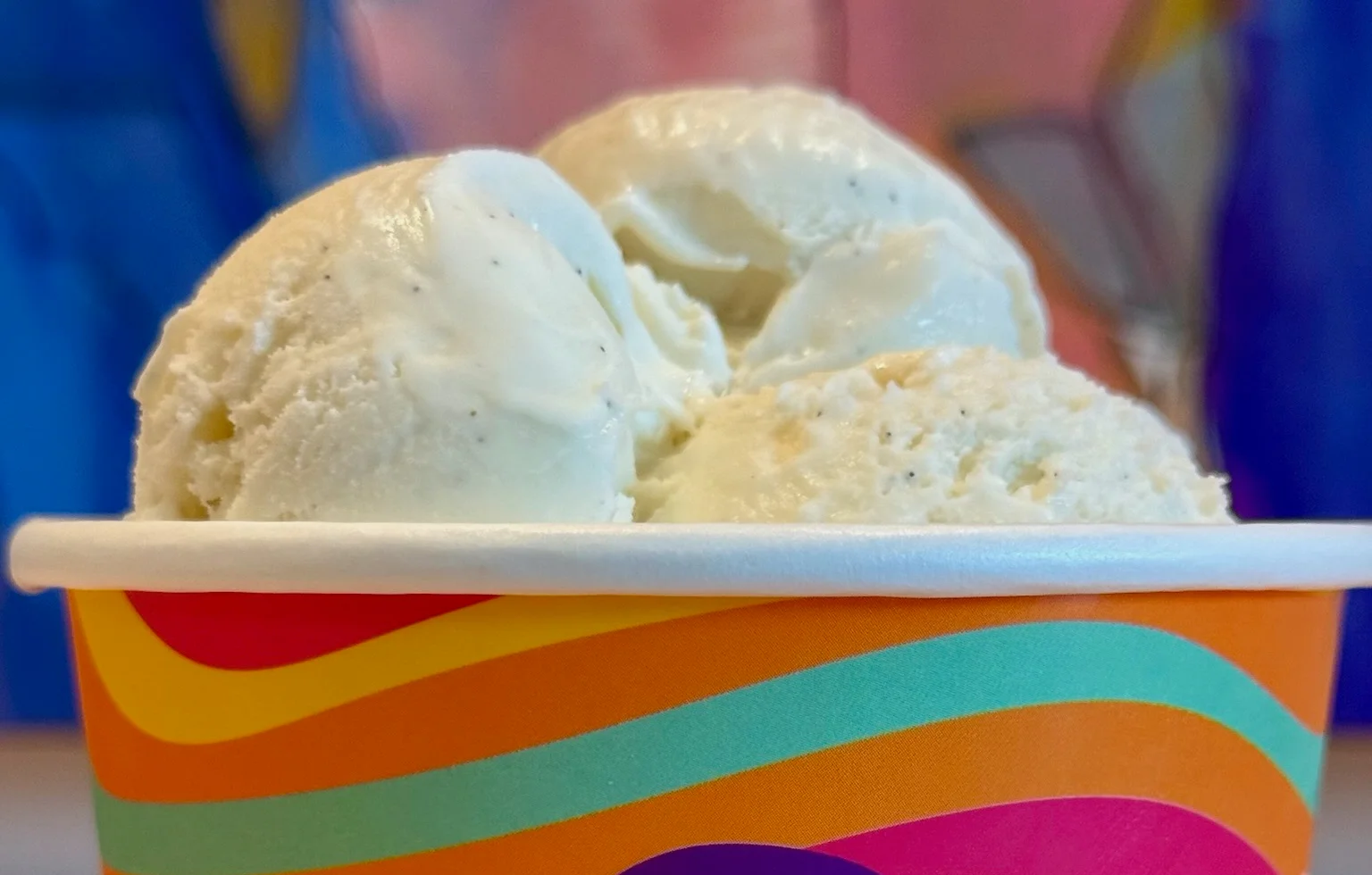 Scoop of vanilla ice cream in a colorful cup