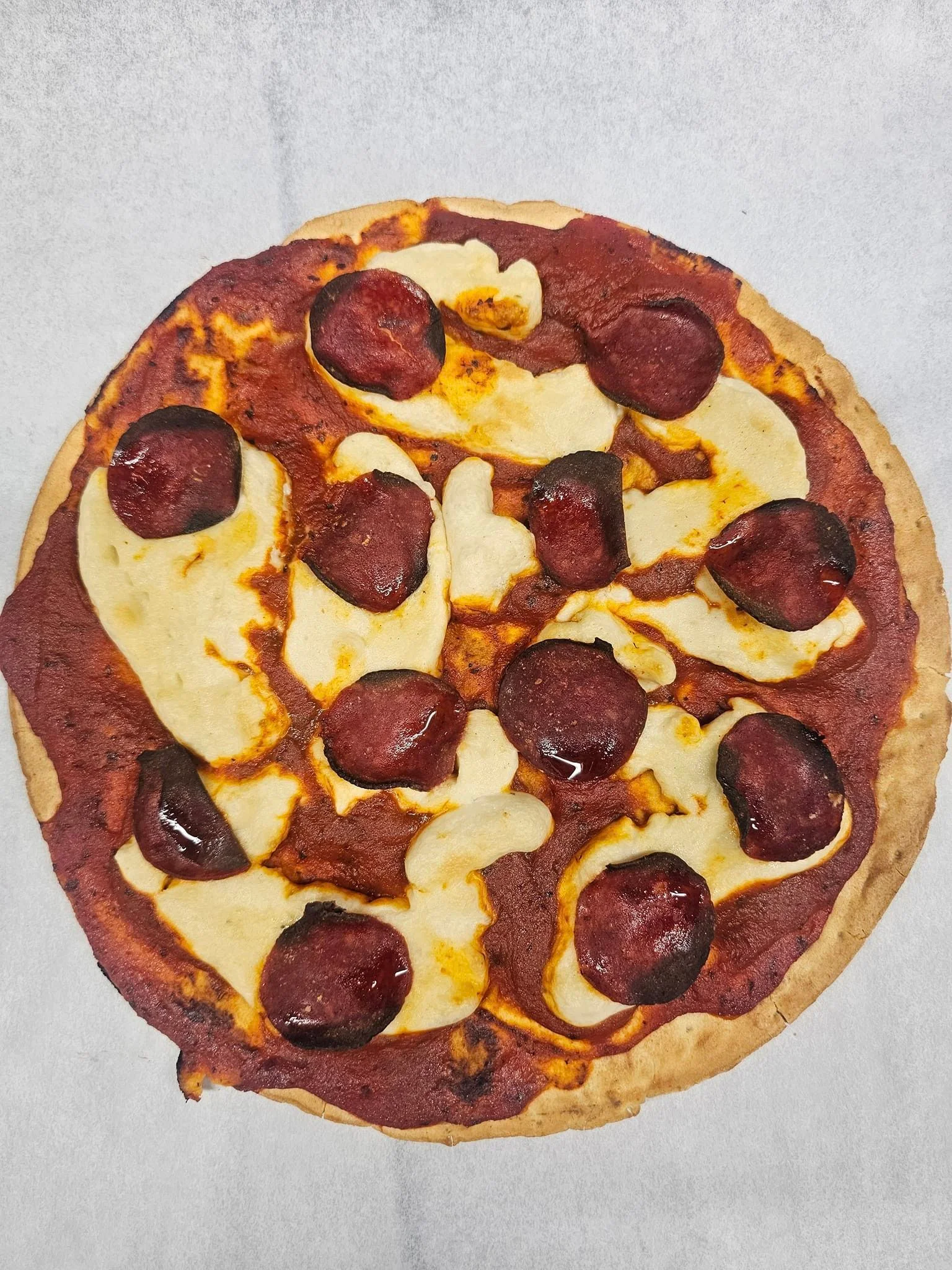 Unique pizza topped with pepperoni and cheese
